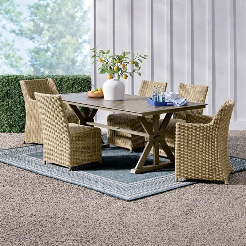 Montville 84-inch outdoor dining table with woven chairs on modern patio setting