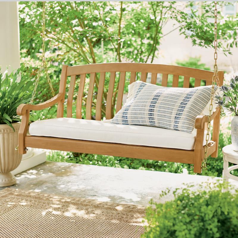 All-natural teak outdoor swing with cushioned seat in elegant garden setting